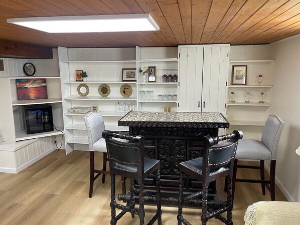 A dining area with a dark wooden table and chairs, surrounded by white shelves with various decorative items. - 12 Min to Great Lakes Naval Station Navy Graduation Family Home (Waukegan)