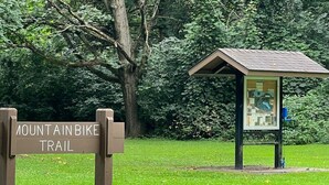 A sign for the Mountain in Bike Trail with a shelter displaying a map. - New! Modern lakeside retreat-hot tub-trails-kayak (La Porte)