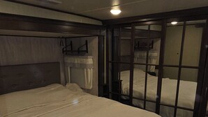 Un dormitorio con una cama grande, una cama más pequeña y un tocador.