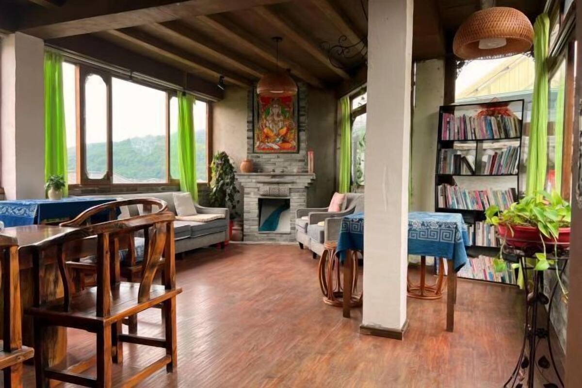 A cozy living room with a fireplace, wooden furniture, and a bookshelf.