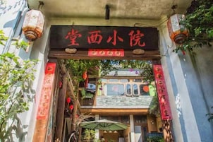 Una puerta china tradicional con adornos rojos y un letrero en la parte superior.
