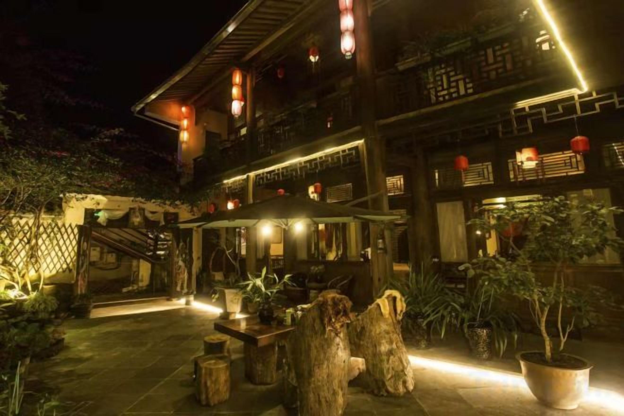 Un edificio tradicional con patio, muebles de madera y plantas en macetas.
