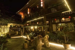 Un edificio tradicional con patio, muebles de madera y plantas en macetas.