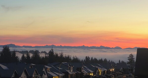 A mountain range at sunset with houses in the foreground.