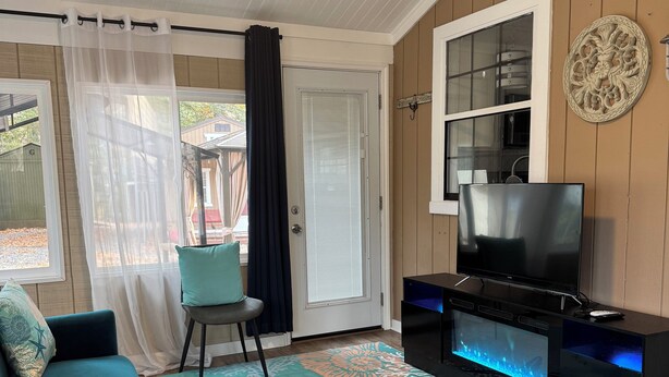 Un salon avec un canapé bleu, un téléviseur à écran plat et un aquarium décoratif.