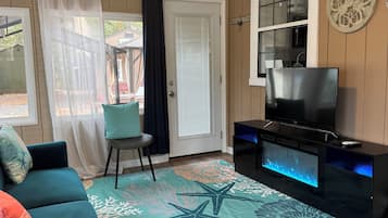 A living room with a blue sofa, a flat-screen TV, and a decorative aquarium.