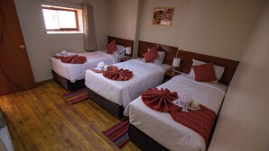 A hotel room with three beds, wooden flooring, and a window. - Encanto San Blas (Cusco)
