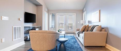 A modern living room with a ceiling fan, a television, and two sofas.