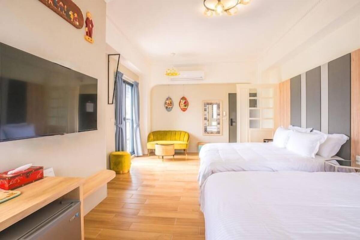 Una habitación de hotel con cama, televisión, escritorio, silla y armario.