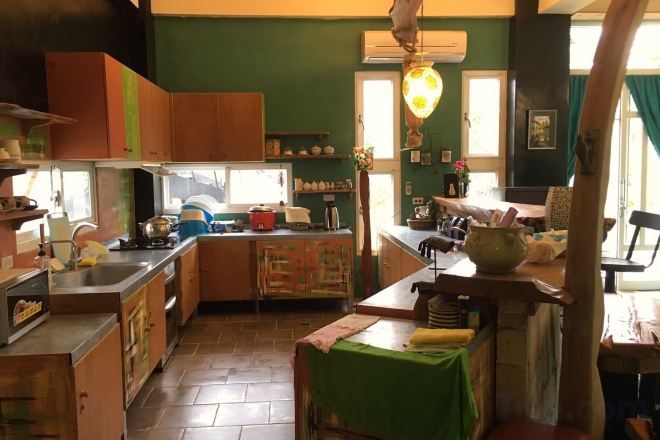 A kitchen with wooden cabinets, a stove, and a dining area with a table and chairs.