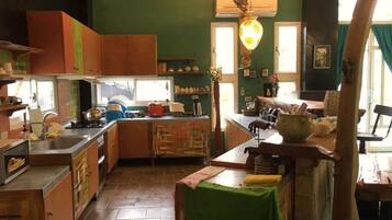 A kitchen with wooden cabinets, a stove, and a dining area with a table and chairs.