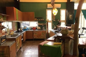 Una cocina con armarios de madera, estufa y comedor con mesa y sillas.
