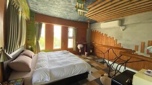 Ein Schlafzimmer mit Bett, Schreibtisch, Stuhl und Fenster.