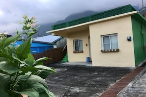 Un edificio residencial con techo plano, una ventana pequeña y una puerta.