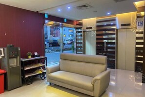 A hotel lobby with a sofa, a vending machine, and an elevator. - Ximen Relite Hotel (Taipei)