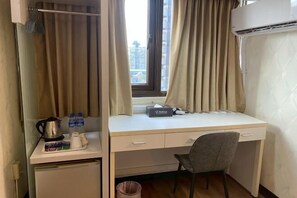 A hotel room with a desk, chair, air conditioning unit, and a window with curtains. - Ximen Relite Hotel (Taipei)