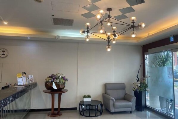 A reception area with a modern chandelier, a reception desk, a seating area, and a large window. - Ximen Relite Hotel (Taipei)