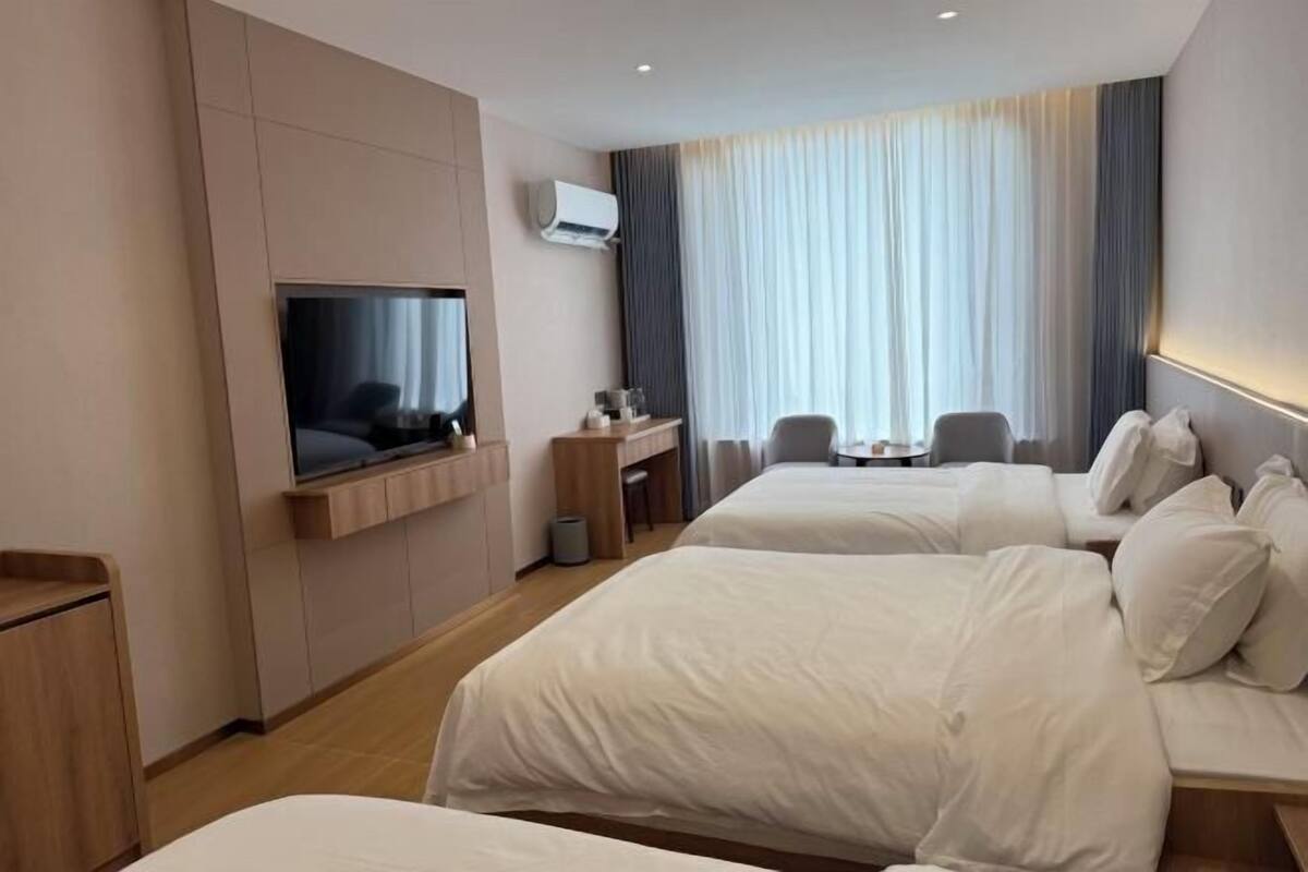 Une chambre d’hôtel avec deux lits, une télévision, un bureau et une chaise.