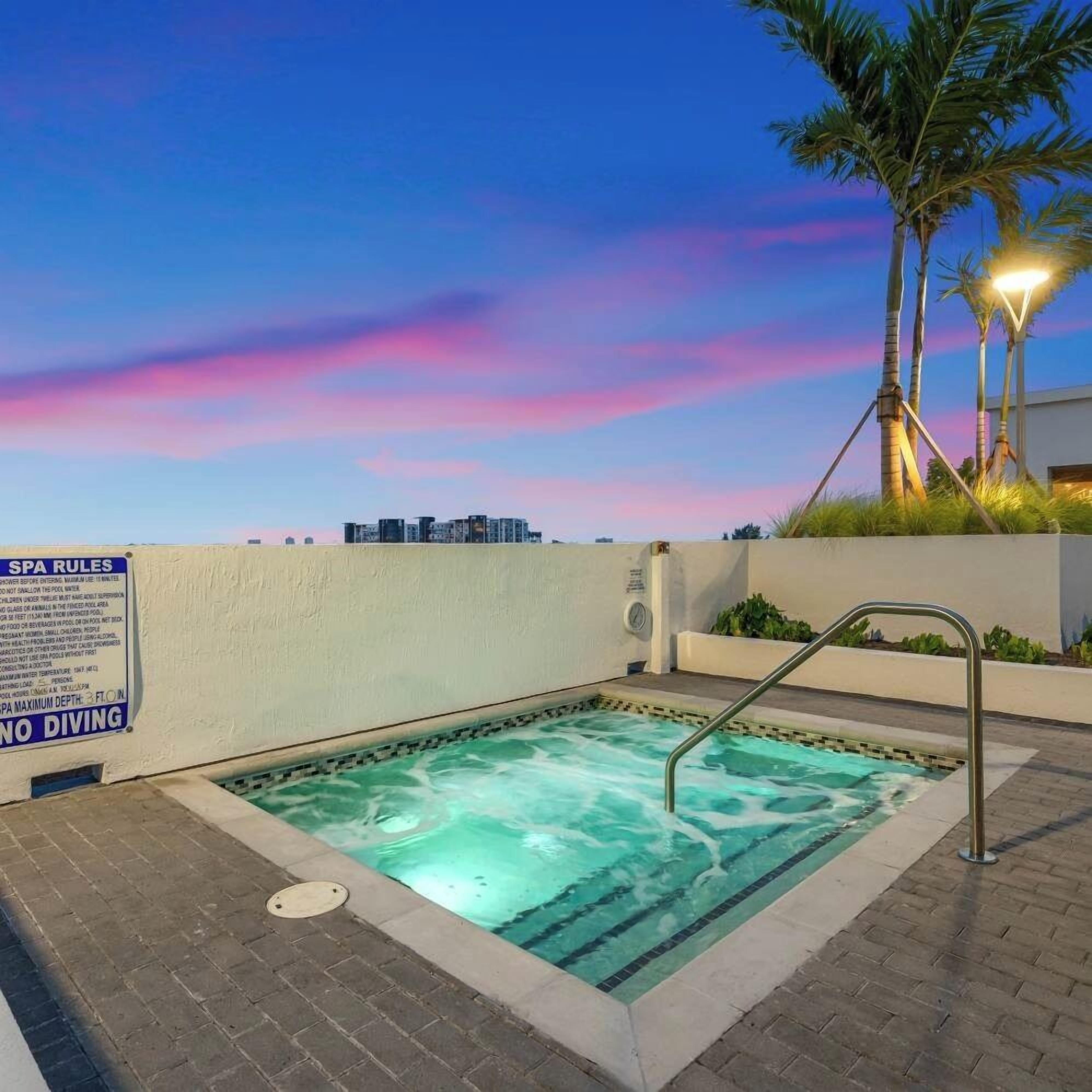 A spa pool with a sign indicating no diving and spa rules.