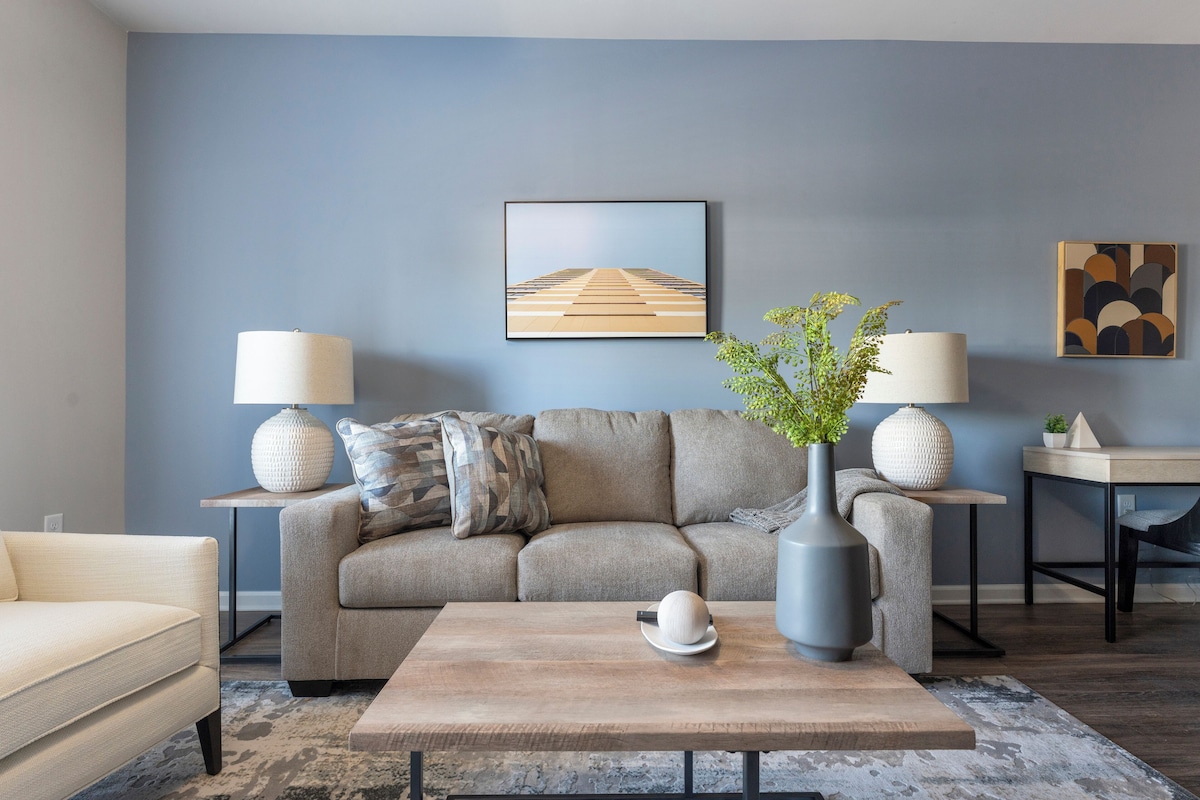 Un salon moderne avec un canapé, une table basse et des lampes.