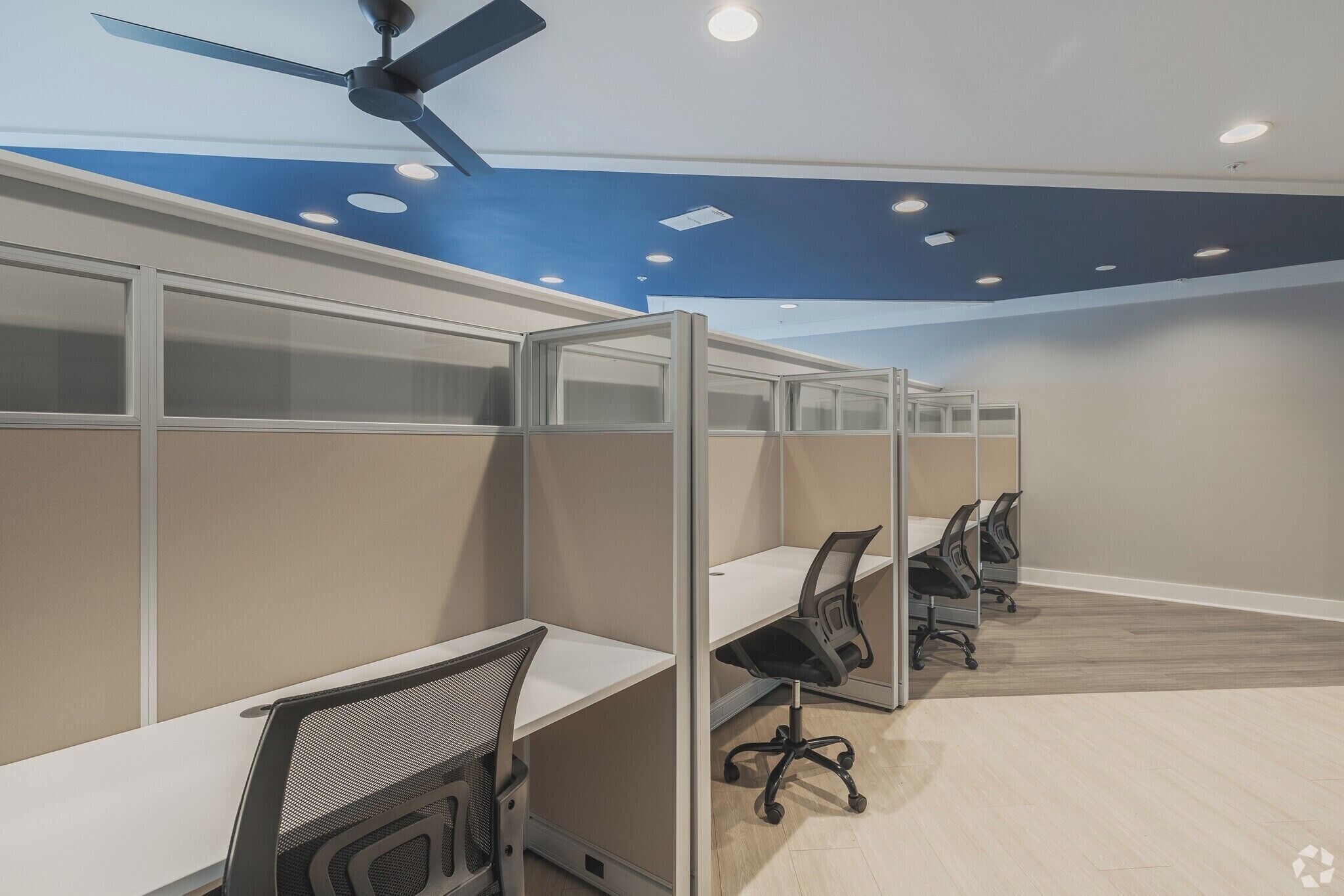 A modern office space with cubicles, desks, and office chairs.