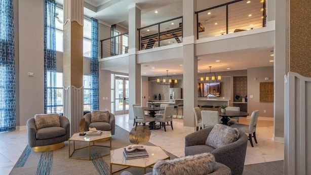 A spacious living area with a high ceiling, a dining area, and a kitchen. - Carolina Forest Furnished Apartments by Landing  (Myrtle Beach)