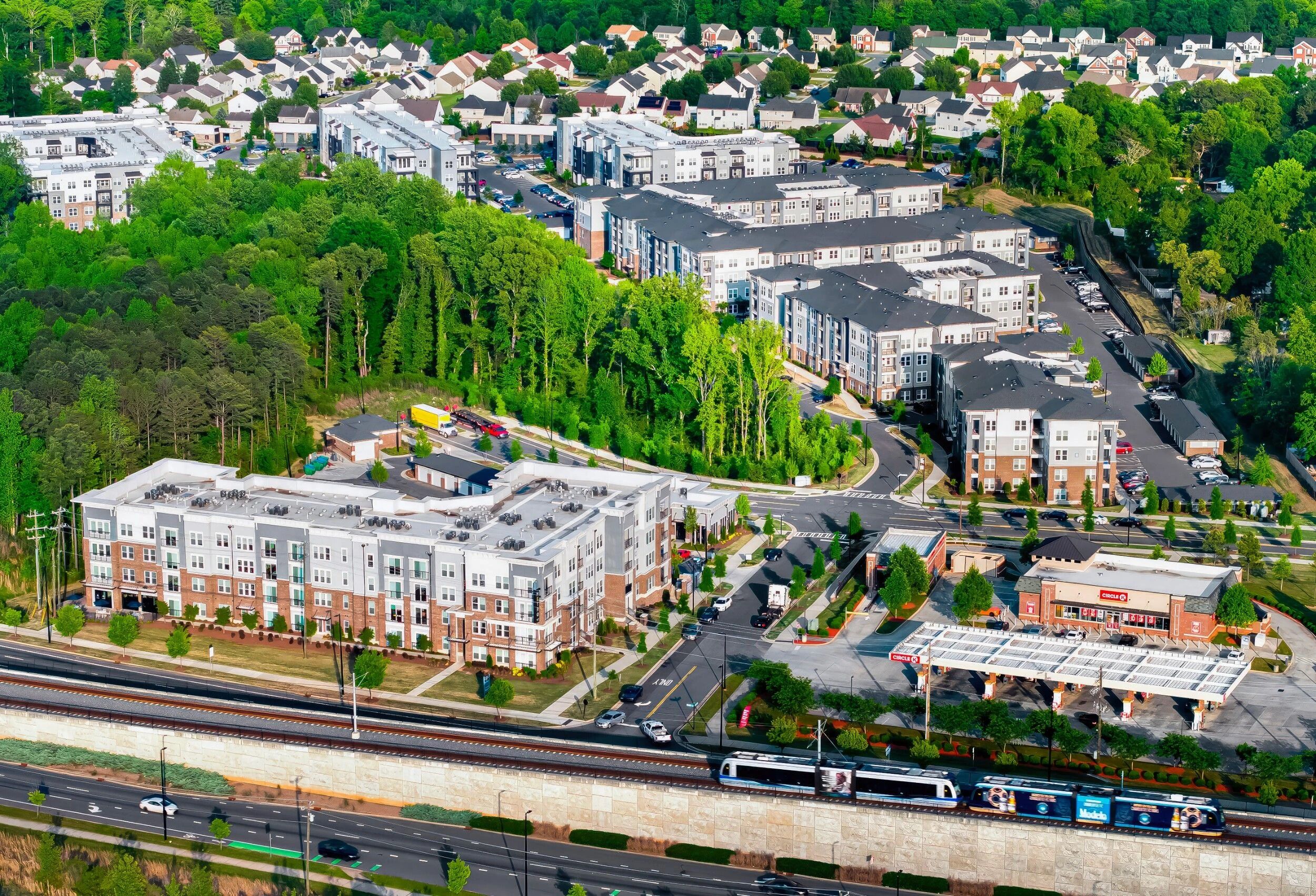 A residential area with multi-story apartment buildings, a gas station, and a highway.