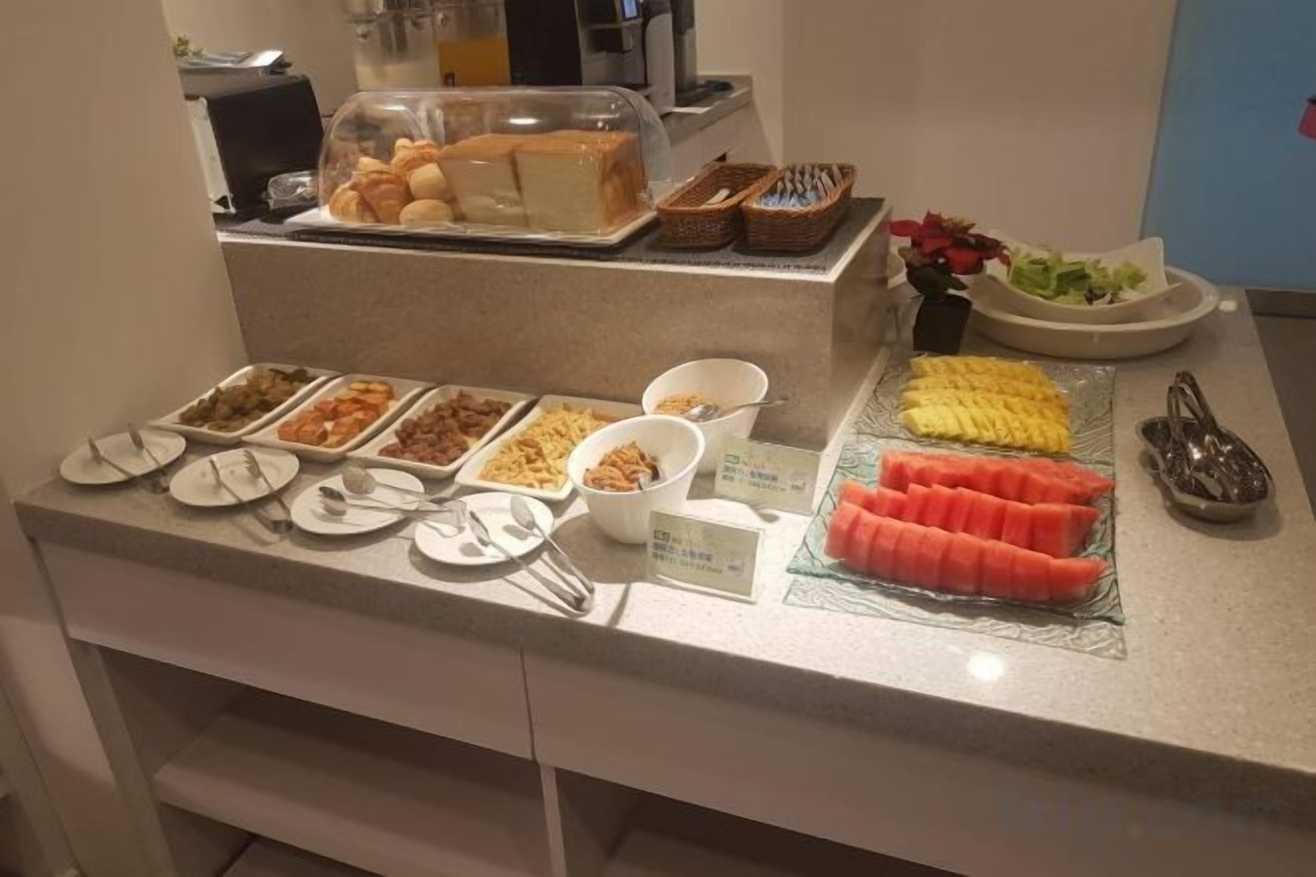 Buffet-pöytä, jossa on tarjolla monenlaista ruokaa ja ruokailuvälineitä.