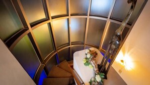 A spiral staircase in a room with a bed and a decorative wall piece. - Only Love Motel (New Taipei City)