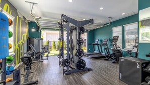 Une salle de sport équipée de matériel de musculation, de tapis de course et de divers appareils de fitness.