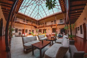 A spacious atrium with high ceilings, a glass dome, and multiple seating areas. - HOTEL CAJAMARCA (Cajamarca)