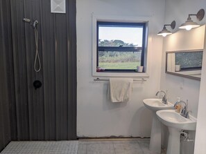 Een douche, handdoeken, zeep, toiletpapier