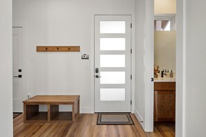 A hallway with a wooden bench, a white door with frosted glass panels, and a small wooden shelf above the door. - Downtown WP Chalet 50 I Hot Tub I Great Views I Car Charger I Bunks I Discounted Attractions (Winter Park)
