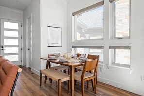 A dining area with a wooden table set for four, surrounded by chairs with woven seats. - Downtown WP Chalet 50 I Hot Tub I Great Views I Car Charger I Bunks I Discounted Attractions (Winter Park)