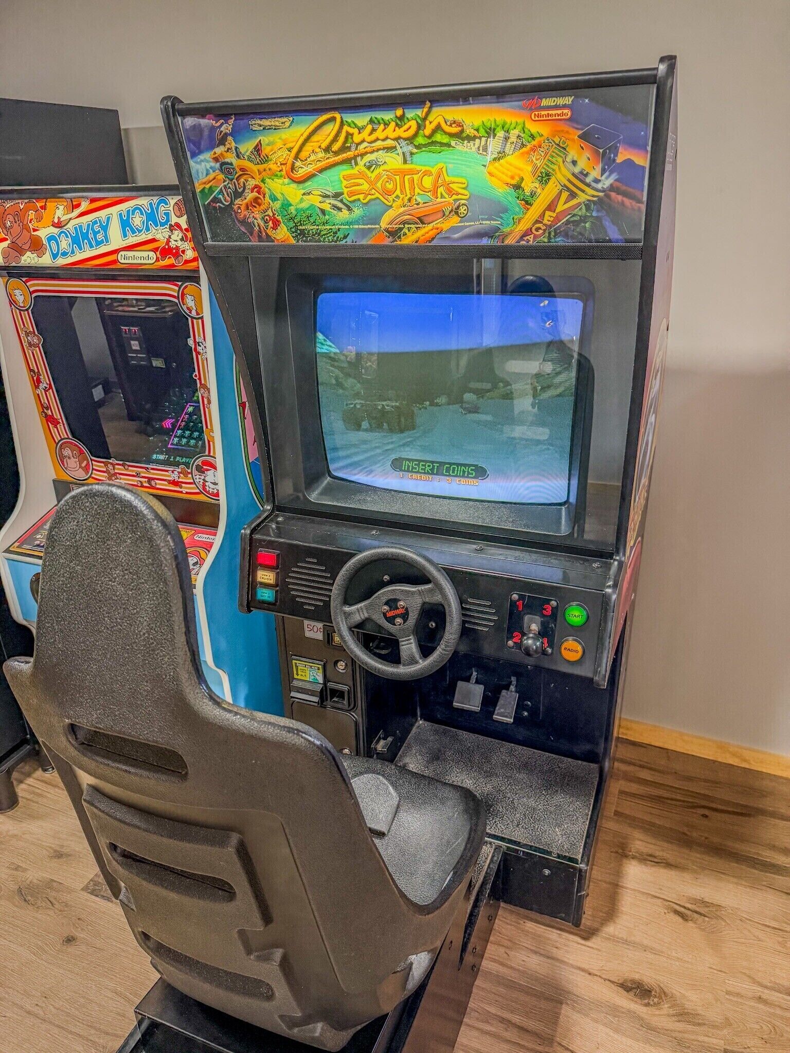 Máquina de videojuegos de estilo retro con volante y pantalla.