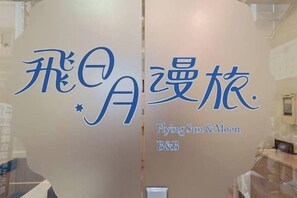A wall with a logo and the name 'Flying Sun & Moon B&B' indicating a bed and breakfast establishment. - Flying Sun & Moon B&B (Nantou)