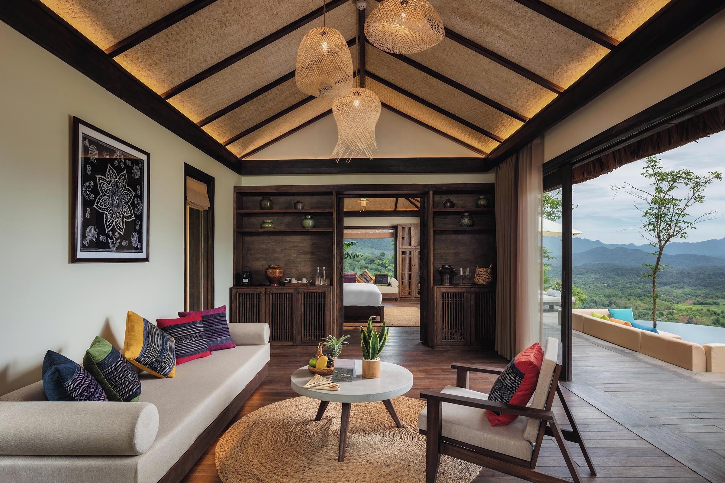Amplia sala de estar con techo alto, un conjunto de sofás, una mesa de centro y vistas al exterior.