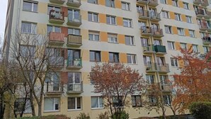 Un immeuble résidentiel à plusieurs étages, doté de balcons, d’un toit plat et d’une façade uniforme.