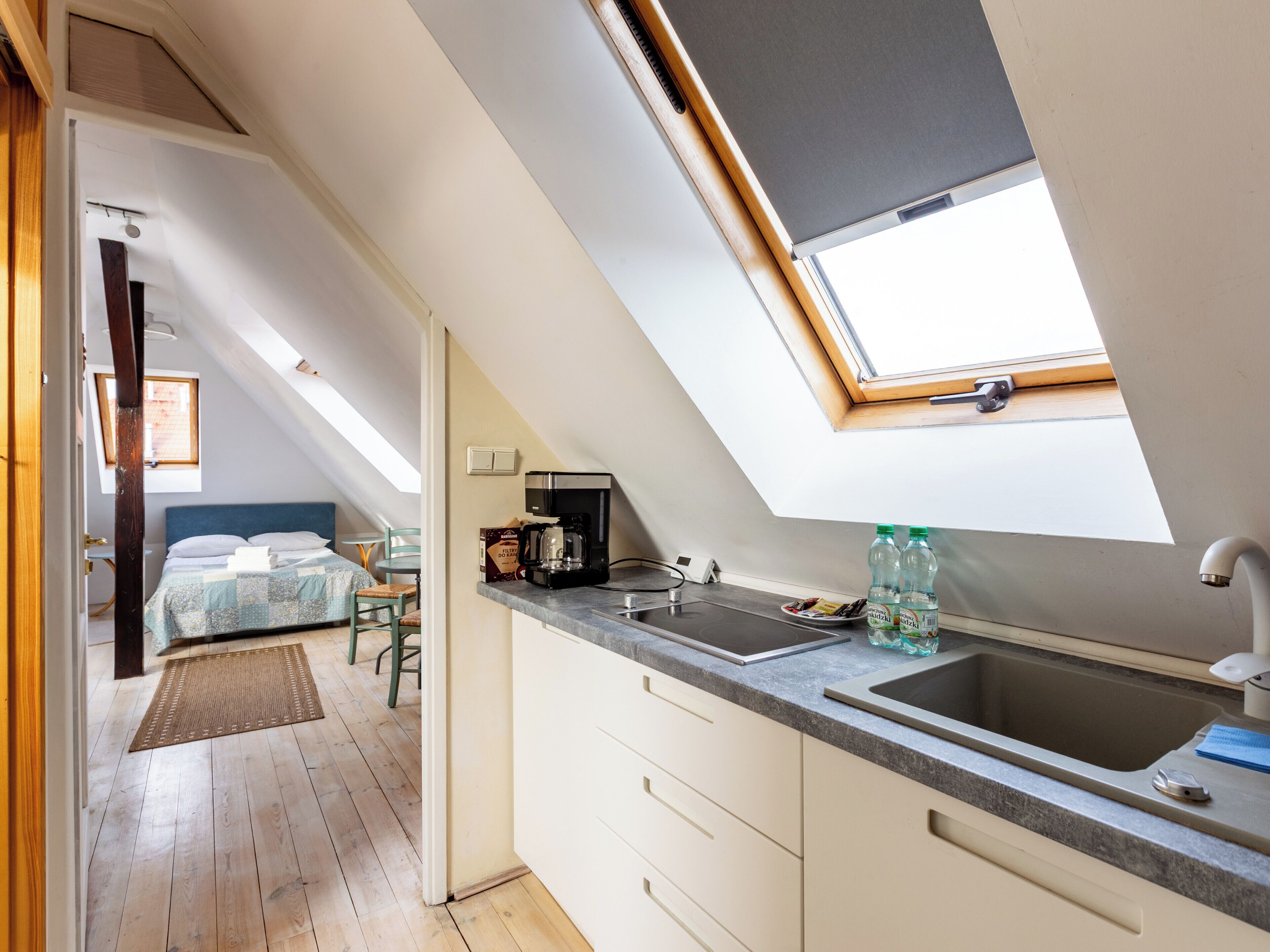 A modern kitchen with a skylight, a coffee maker, and a sink.