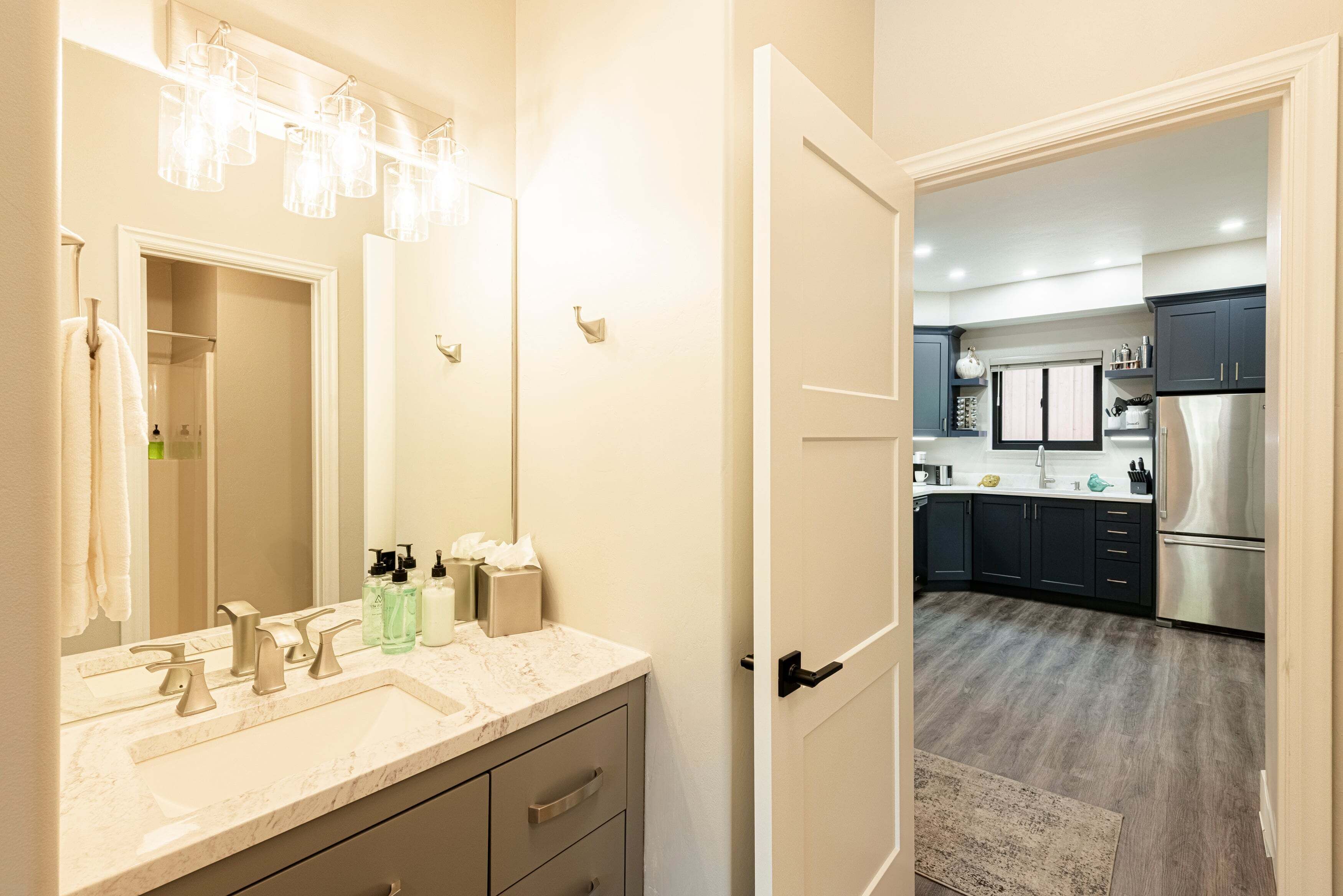 A bathroom with a sink, mirror, and towel rack.