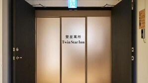 A hotel entrance with a sliding door and a sign indicating 'Twin Star Inn'. - Twin Star Inn (Taipei)