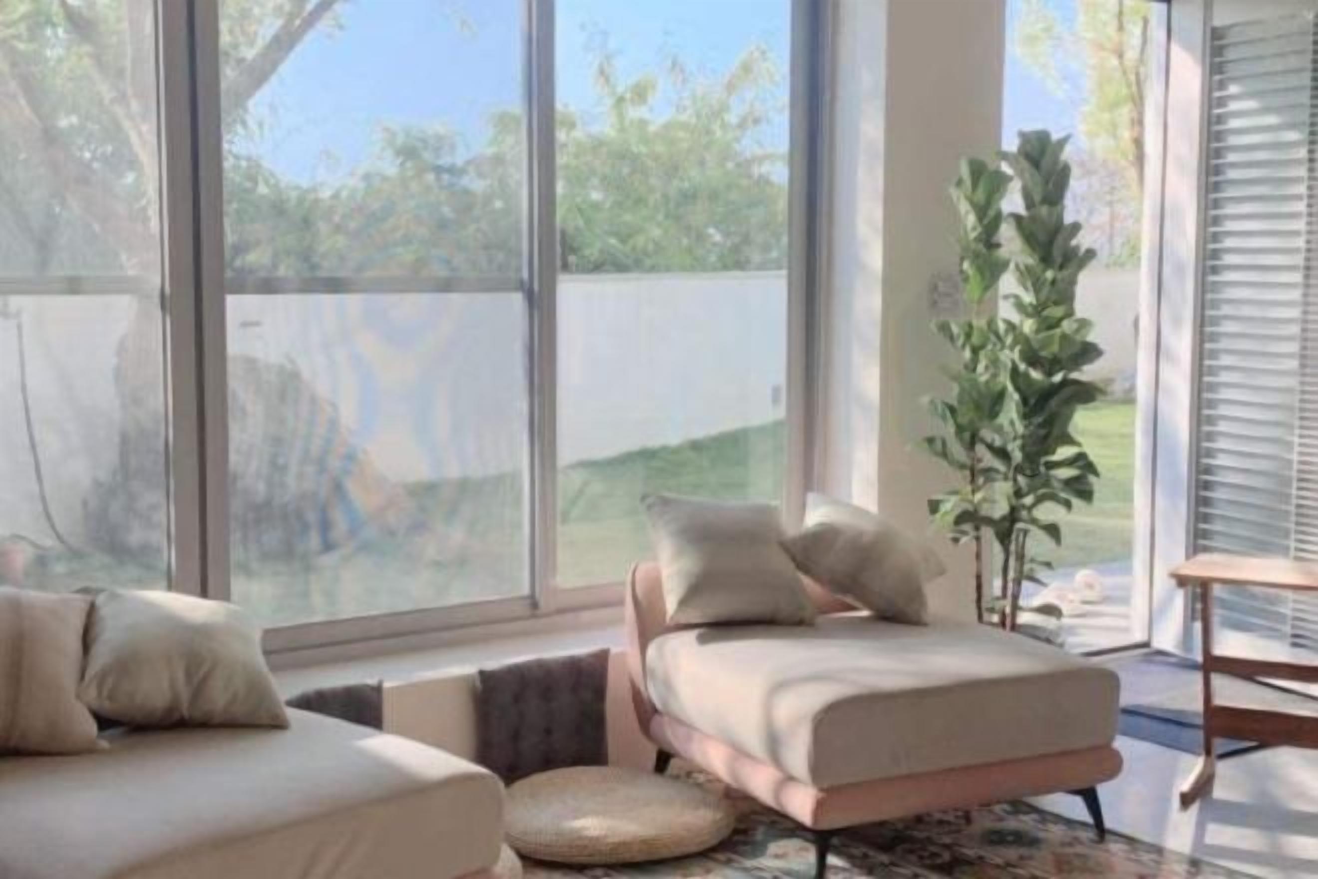 A modern living room with a sofa, a coffee table, and a large window.