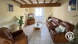 A living room with two leather sofas, a coffee table, a TV on a wooden stand, and a potted plant. - La tramontane - ELNE (ELNE)
