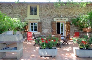A stone building with a patio area featuring outdoor furniture and potted plants. - La tramontane - ELNE (ELNE)
