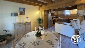 A rustic kitchen with wooden beams, a dining area with a table set for two, and a view into the adjacent dining room. - La tramontane - ELNE (ELNE)