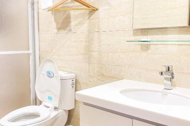 Ein Badezimmer mit Toilette, Waschbecken und einem Glastischchen darüber.