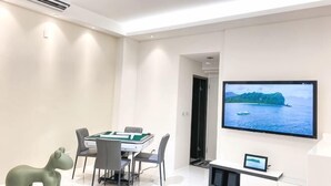 Ein Konferenzraum mit Tisch, Stühlen, einem Fernseher und einer Leinwand, die eine schöne Aussicht zeigt.