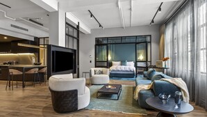 A modern living room with a sofa, armchair, coffee table, and a TV.