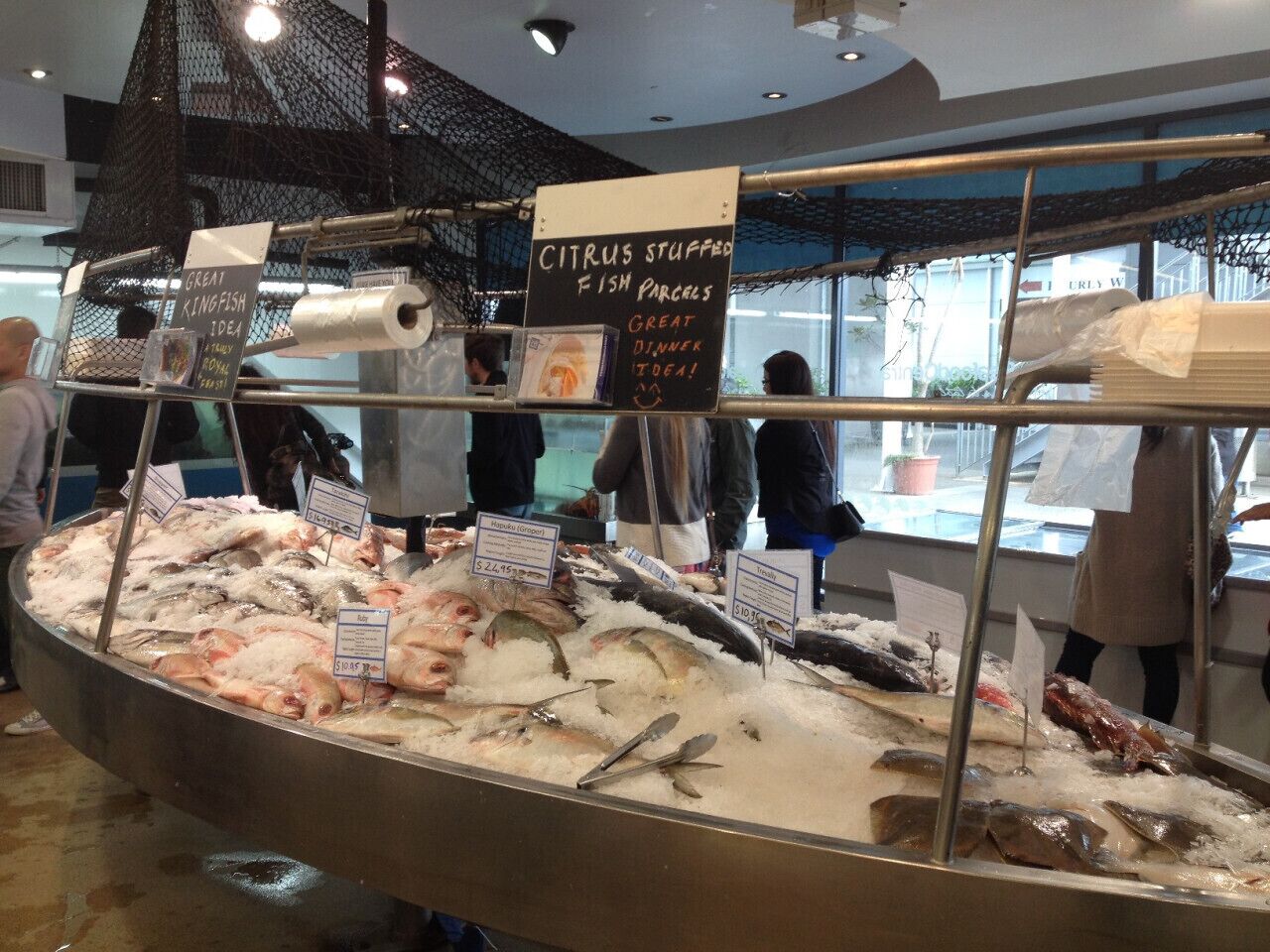 A seafood display with various fish and citrus stuffed fish parcels.