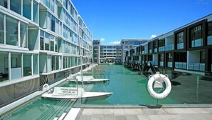 Un navire de croisière moderne doté de balustrades en verre, d’une piscine et de bouées de sauvetage.